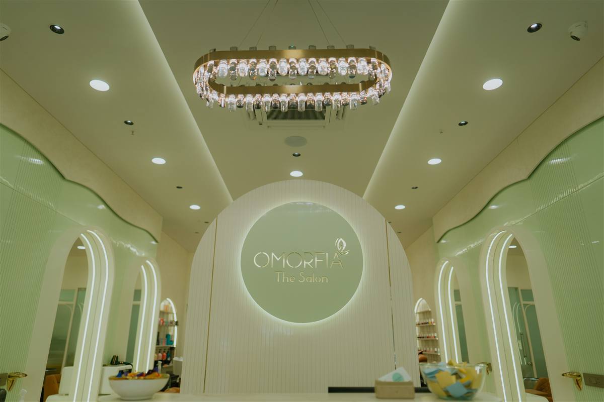 Omorfia The Salon — chandelier and illuminated OMORFIA logo on wall